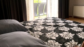 A bedroom with a bed, a window with curtains, and a view of the outside. - Gnt Plus (Tbilisi)