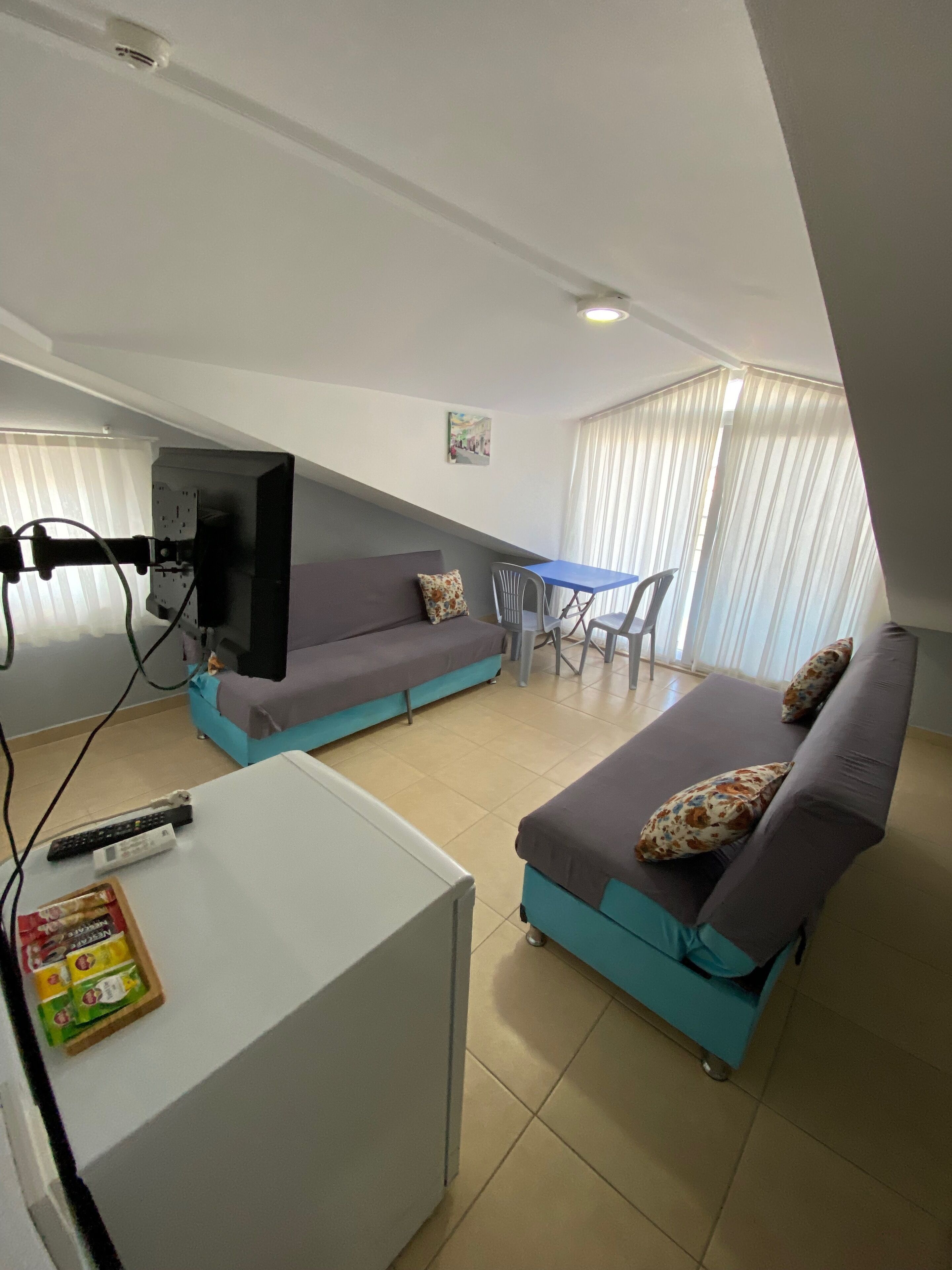 A compact living space with a sofa, a small table, and a television.
