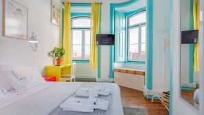 Une chambre d’hôtel moderne avec un grand lit, une télévision et une vue sur la ville.