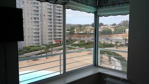 A view from a window overlooking a parking lot and a residential area with tall buildings. - Departamento Algarrobo Condominio Laguna (Algarrobo)