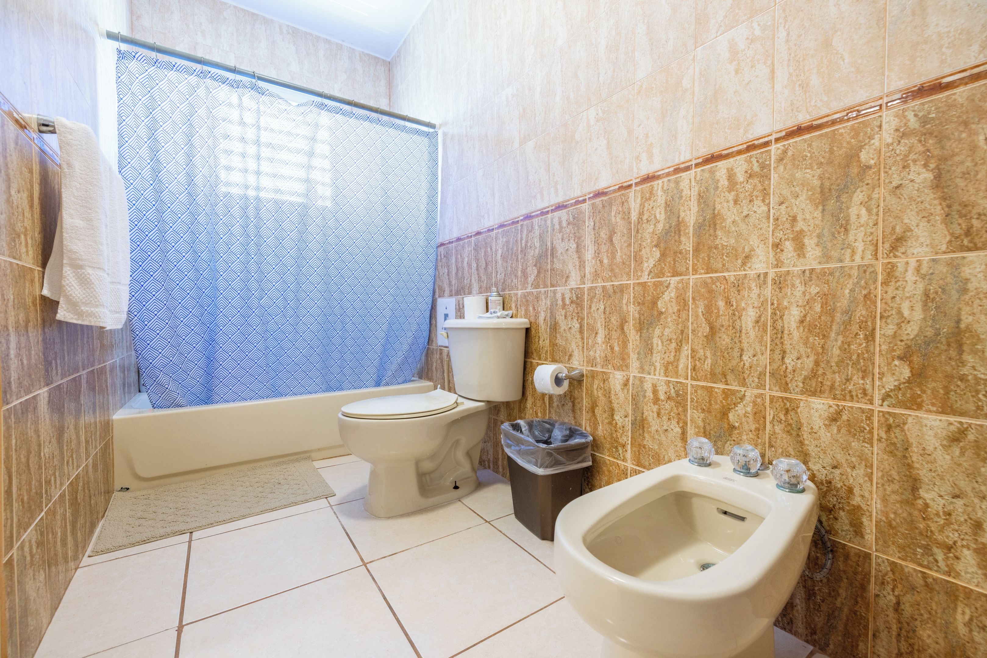 Un baño con inodoro, bidé y cortina de ducha.