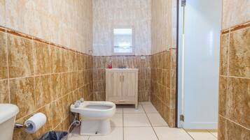 A bathroom with a toilet, bidet, and sink.