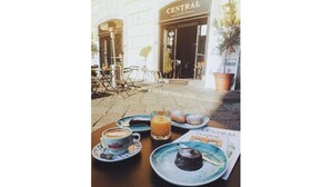 A table with a coffee cup, a glass of juice, and a plate of food outside a building with a sign reading "CENTRAL". - NovaNova (Naples)