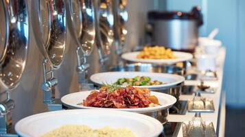 A buffet line with various dishes and a coffee station.
