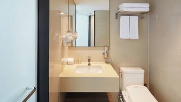 A modern bathroom with a sink, mirror, and toilet.