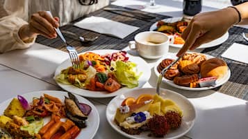 Una mesa con diversos platos, como ensaladas, carnes y postres, que sugiere un ambiente de comedor.