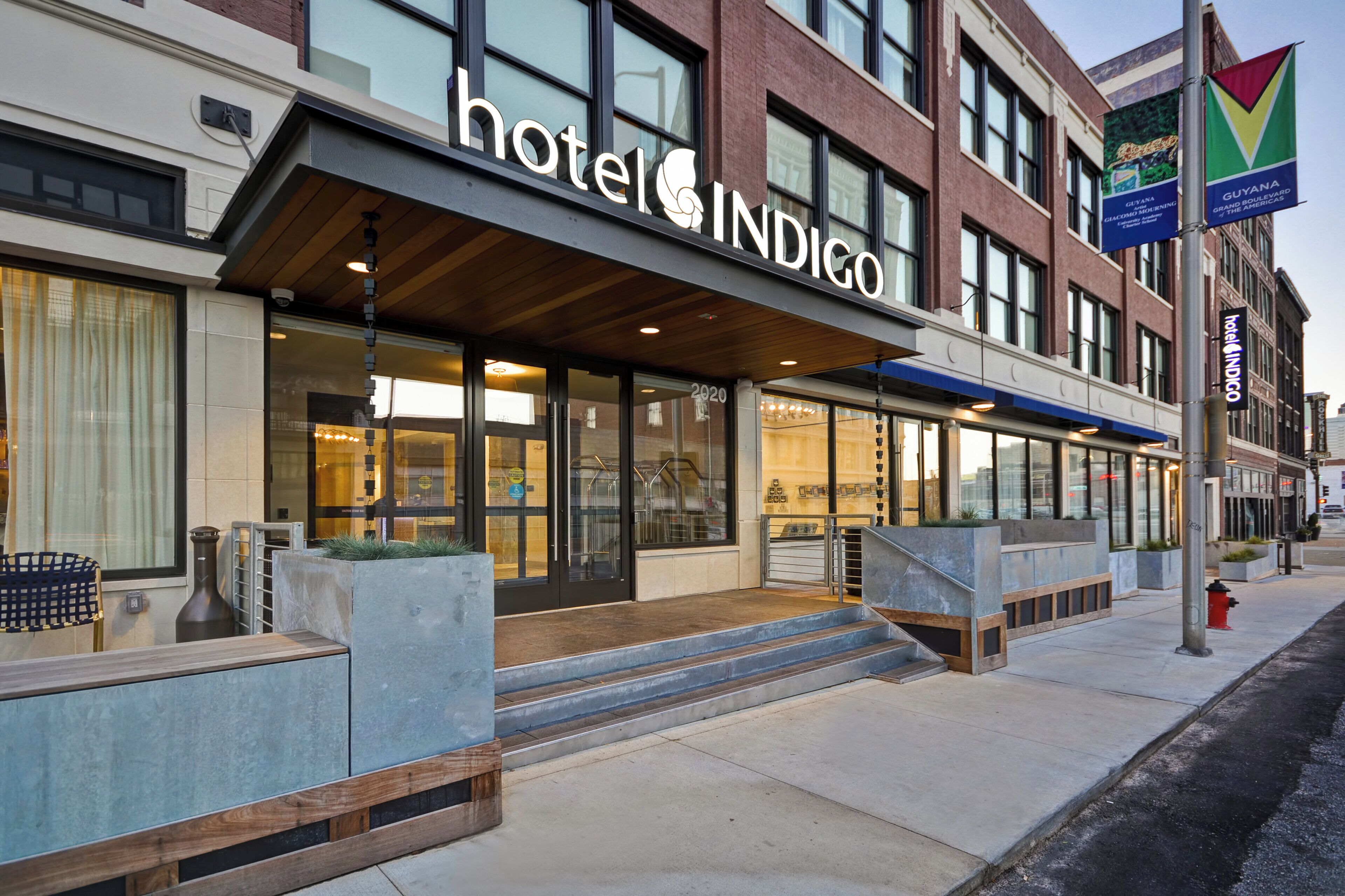A hotel with a modern facade, large windows, and a prominent entrance with steps leading up to the door.