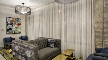 Uma sala de estar moderna com um sofá seccional, uma mesinha de centro e um lustre grande.