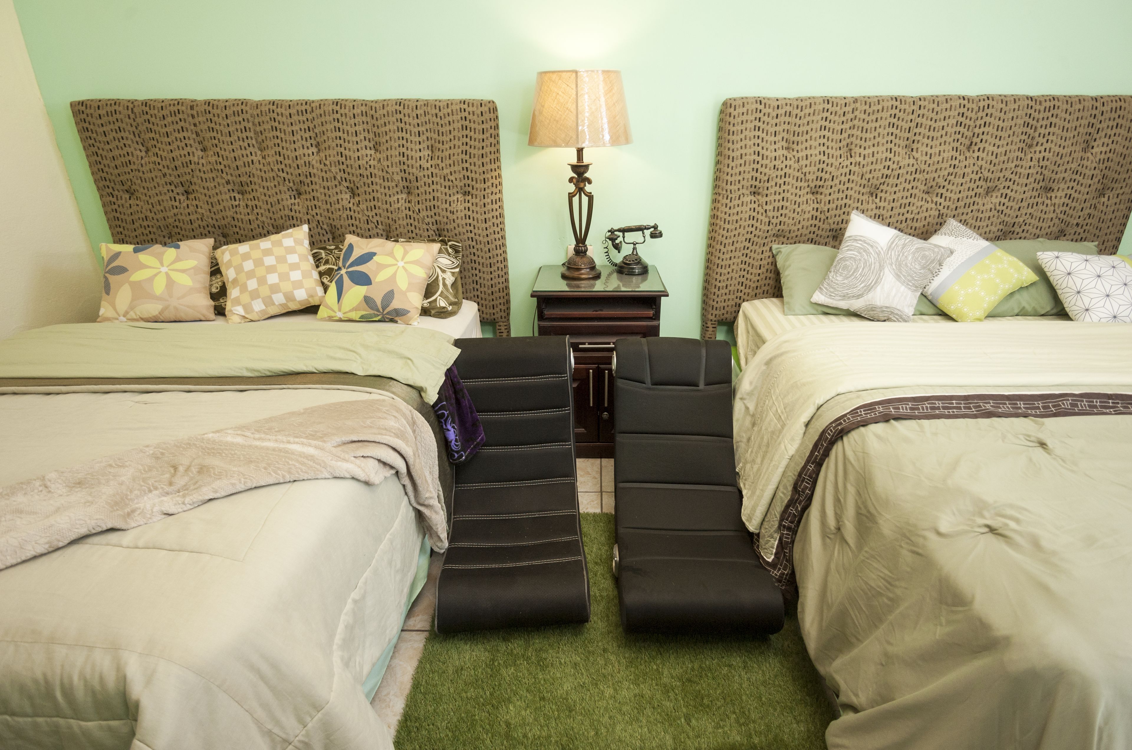 Habitación doble con dos camas, una mesita de noche con lámpara y una pequeña mesa.