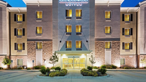 A hotel with a modern facade, multiple windows, and a well-lit entrance. - Candlewood Suites Austin North by IHG (Austin)