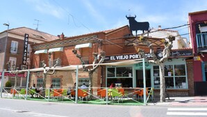 Ein Gebäude mit einem Schild, auf dem 'EL VIEJO PORTER' steht, und einer Skulptur eines Stiers auf dem Dach.