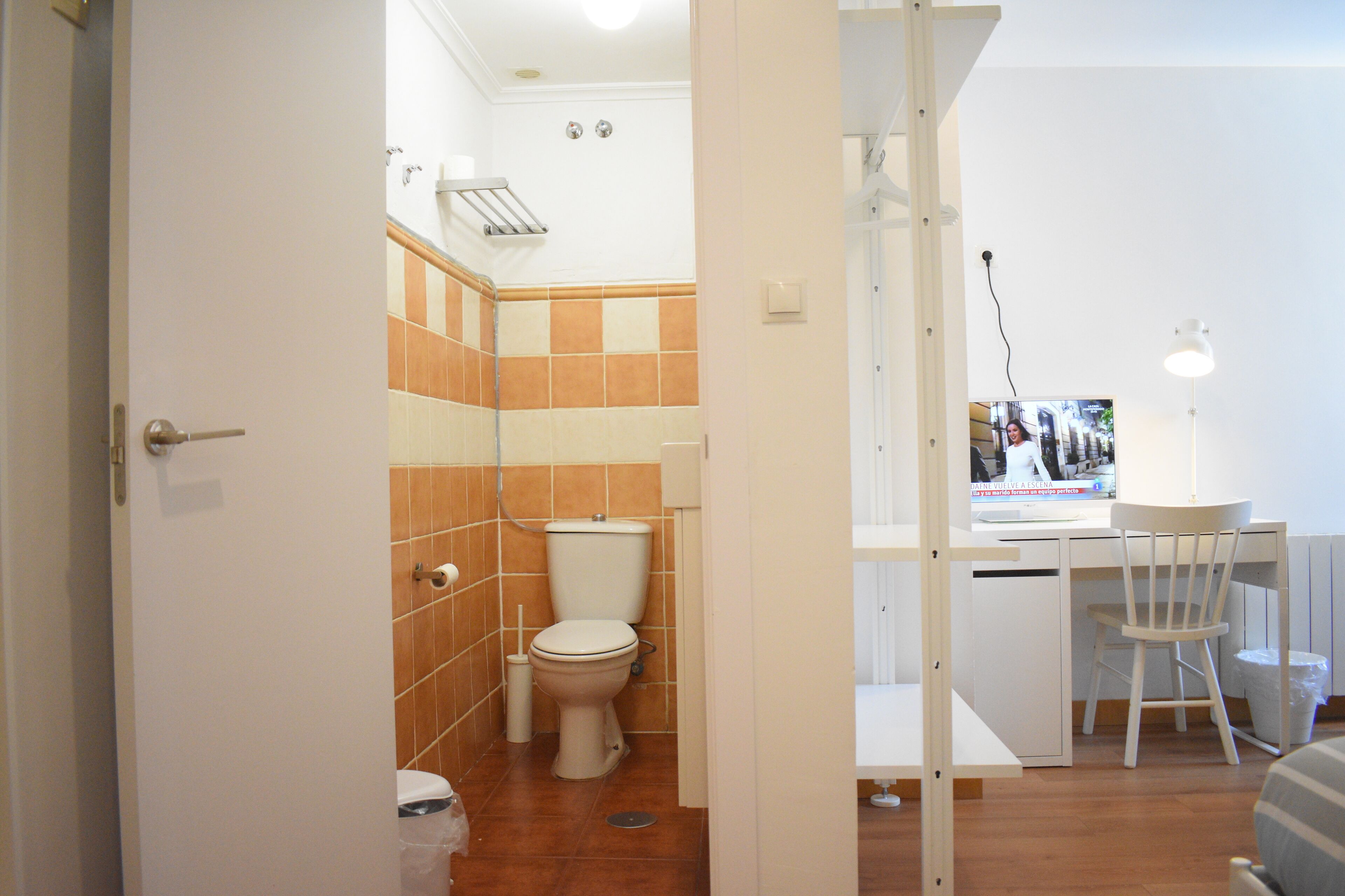Une salle de bain avec des toilettes, un lavabo et une chaise.