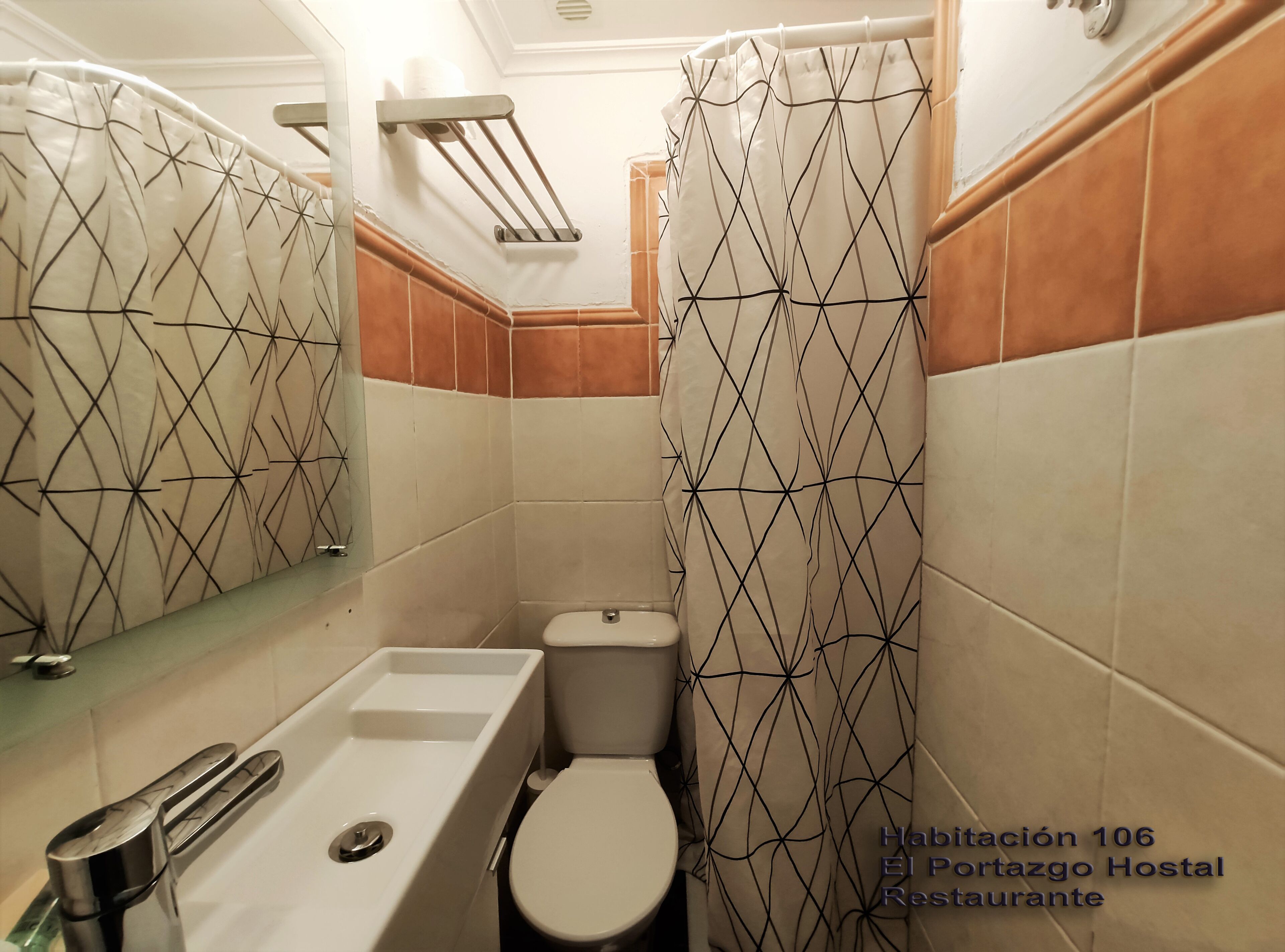 Un baño con bañera, inodoro y cortina de ducha de diseño geométrico.