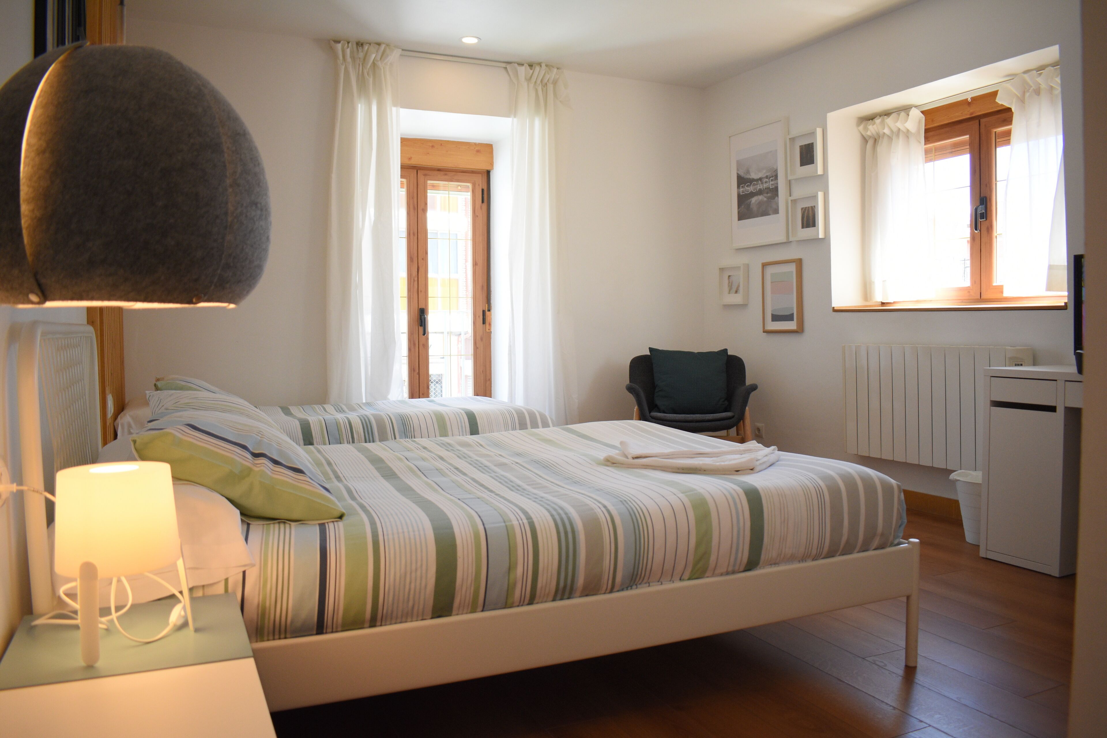 Cubrecamas, escritorio y espacio para trabajar con laptop 