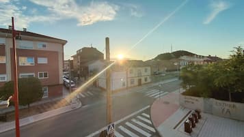 Vista de la calle con edificios, un paso de peatones y cielo despejado.