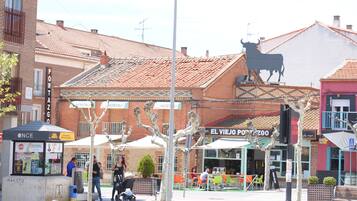 Straatbeeld met een restaurant genaamd "El Viejo Postezgo" en een stierbeeld op een gebouw.