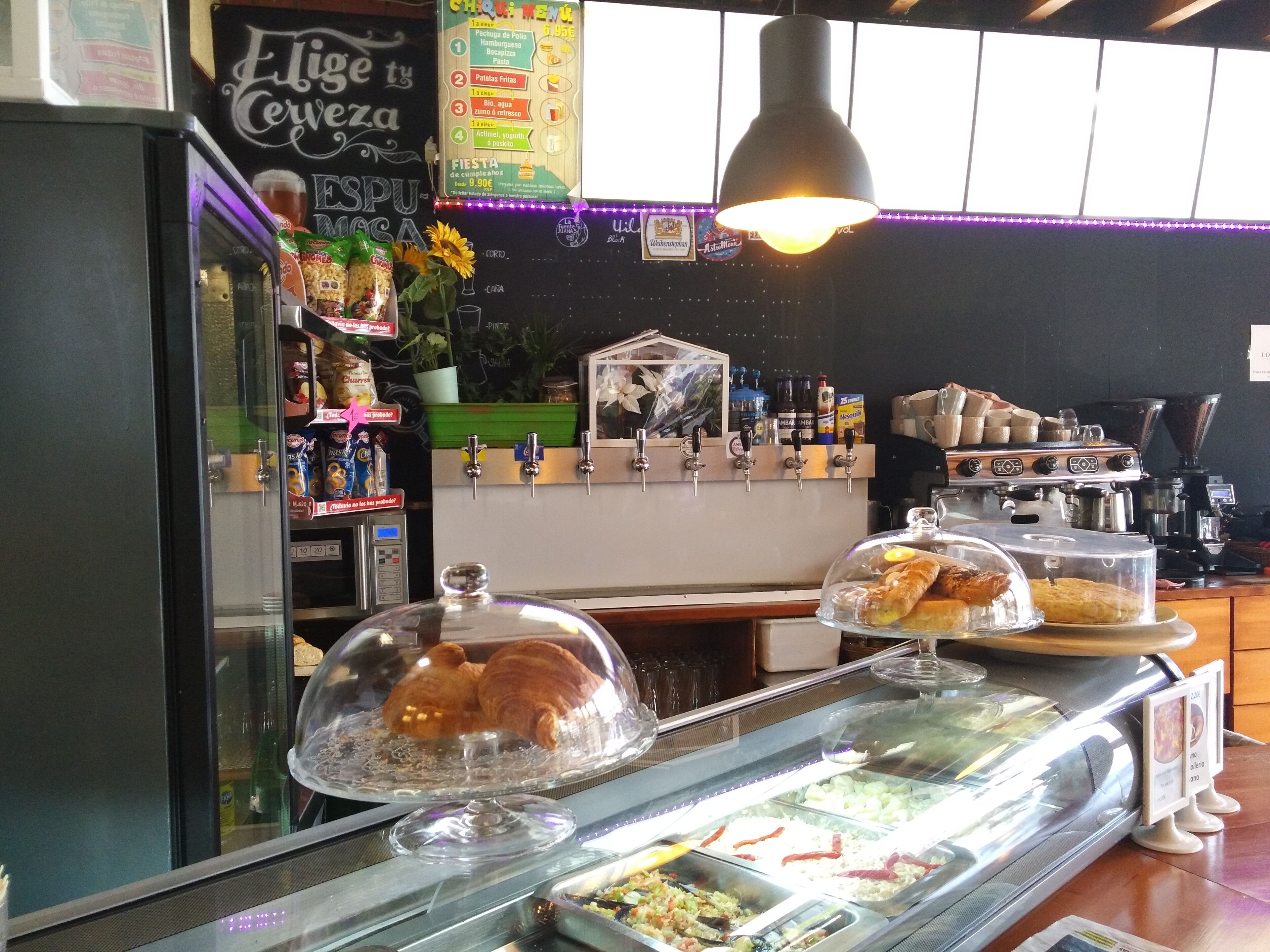 A bakery counter with pastries and a coffee machine.