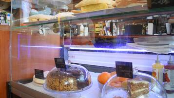 Vitrina de panadería con diversos productos horneados y postres.