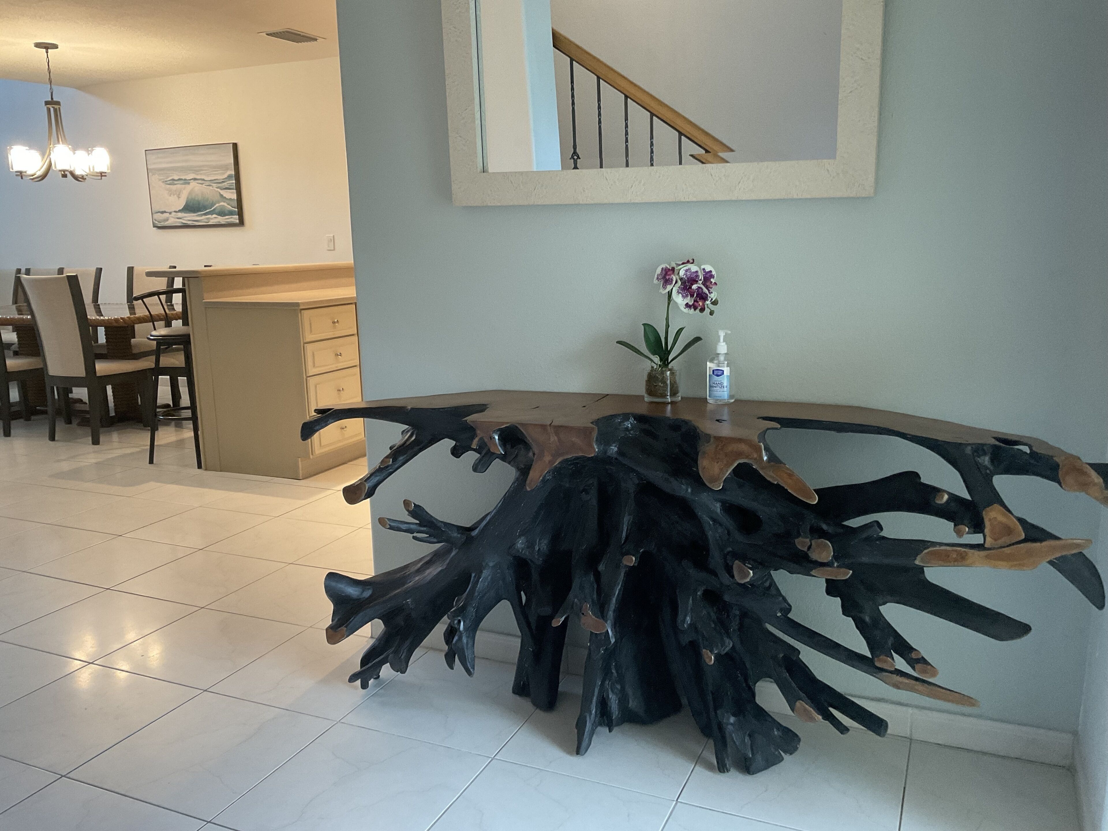 Una cocina moderna con una isla de madera original, una zona de comedor con sillas y una escalera.