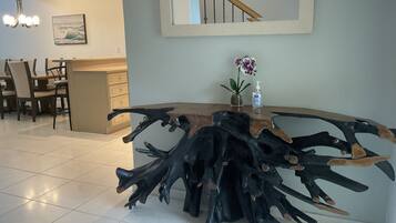 Una cocina moderna con una isla de madera original, una zona de comedor con sillas y una escalera.