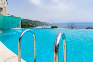 A clear blue pool with metal railings, overlooking a coastal landscape with hills and a view of the sea. - Beautiful View, Pool ,two steps from city center !! (Taormina)