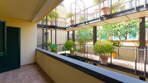 A balcony with potted plants and a view of the street. - Beautiful View, Pool ,two steps from city center !! (Taormina)