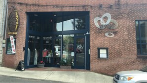A brick building with a storefront labeled "The Sanctuary Boutique" and a sign indicating it is open.