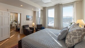 A bedroom with a large bed, a desk, and a chair.