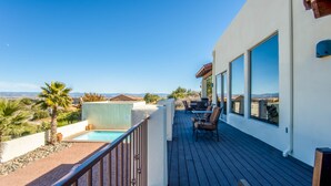 Una terraza con piscina, mobiliario exterior y vistas al paisaje.