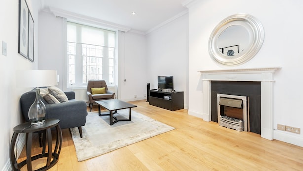 A modern living room with a sofa, coffee table, and fireplace.