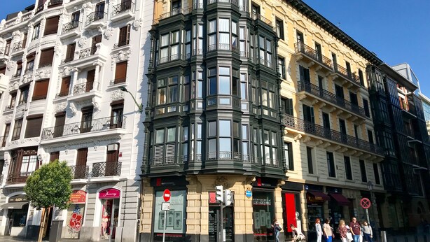 A corner building with ornate facades, a shop at the ground level, and pedestrians on the sidewalk. - Very central apartment in Bilbao a few meters from Gran Vía,  E-BI-752. (Bilbao)