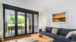 A living room with a grey sofa, a wooden coffee table, and a painting on the wall. - El Rincon del Golf I - Isla Canela Golf GRHI6P06 (Isla Canela)