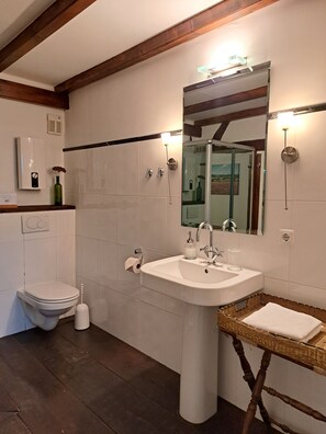 Ein Badezimmer mit Waschbecken, Toilette, Spiegel und Dusche.