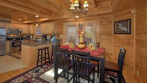 L’intérieur d’un chalet en bois comprend une cuisine, un coin repas et une grande fenêtre.