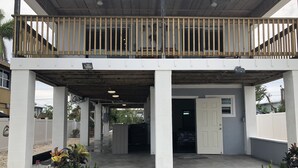 A covered outdoor area with a wooden railing, concrete pillars, and a tiled floor. - "Canal-Front Paradise in Big Pine Key-Relax &Explore the keys" (Big Pine Key)