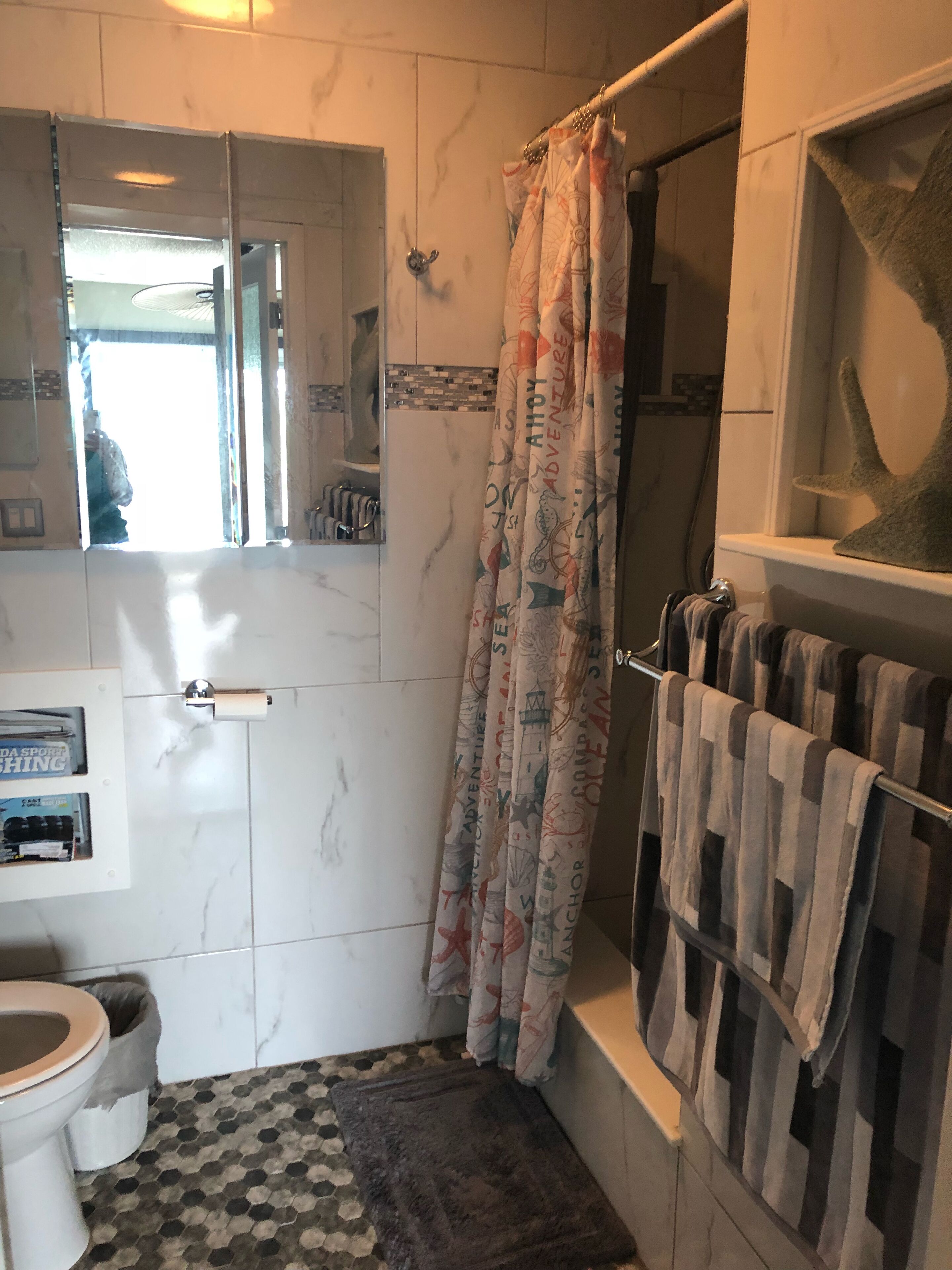 Een badkamer met douche, toilet en wastafel.