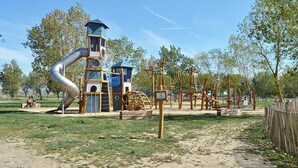 Ein Spielplatz mit Rutsche, Klettergerüsten und Schaukeln.
