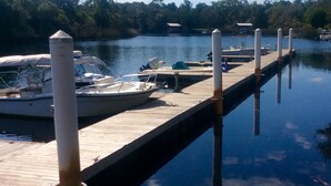 A dock with boats and a wooden pier extending into calm water. - Romantic Spa Experience in Luxurious Creekside Honeymoon Cottage in the Landings (Steinhatchee)
