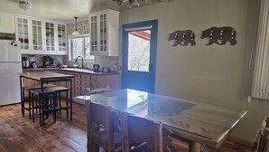 A kitchen with wooden cabinets, a dining table, and chairs. - Cabin in bass lake vacational (Wishon)