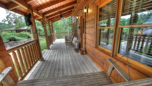 A wooden deck with a railing, a bench, and a potted plant. - Bears Den, Pigeon Forge, Arcade game, Hot Tub (Pigeon Forge)