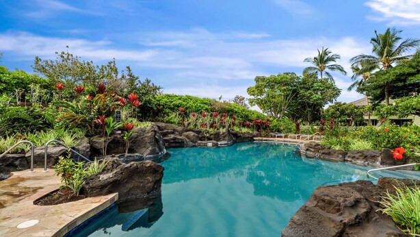 A swimming pool with a natural rock design, surrounded by lush greenery and tropical plants. - 2026 Waikoloa Hilton pool pass included 6 guests daily, available through 2026! (Waikoloa Village)
