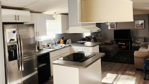 A modern kitchen with a built-in island, stainless steel appliances, and a large pendant light. - Beautiful Waterfront Home on Lake Gaston + Pontoon Rental Option (Henrico)