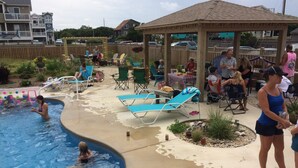 A swimming pool area with lounge chairs and a covered seating area. - Direct Beach Access, Priv. Saltwater Pool,  Hottub, Elevator, BR 5; bath 5 (Kill Devil Hills)