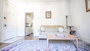 Un salón con sofá, una mesa de centro y una alfombra estampada.