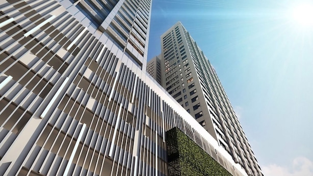 Un moderno edificio de gran altura con una fachada singular que presenta listones verticales y un jardín vertical de color verde.