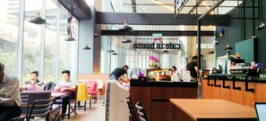 A modern cafe with a counter, seating area, and large windows. - Summer Suites KLCC Apartments By Soulasia (Kuala Lumpur)