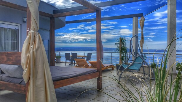 A balcony with a bed, lounge chairs, and a view of the sea. - Ark Beach Hotel (Split)