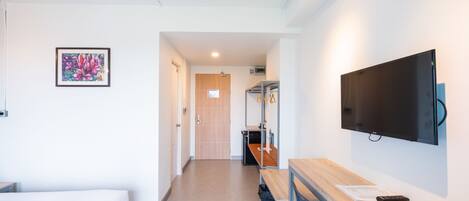 Habitación de hotel con cama, escritorio, silla, televisión y un cuadro en la pared.