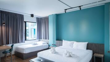 A modern hotel room with two beds, a desk, and a chair.