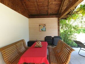 Relax in a serene outdoor seating area surrounded by lush greenery, featuring a table and benches.